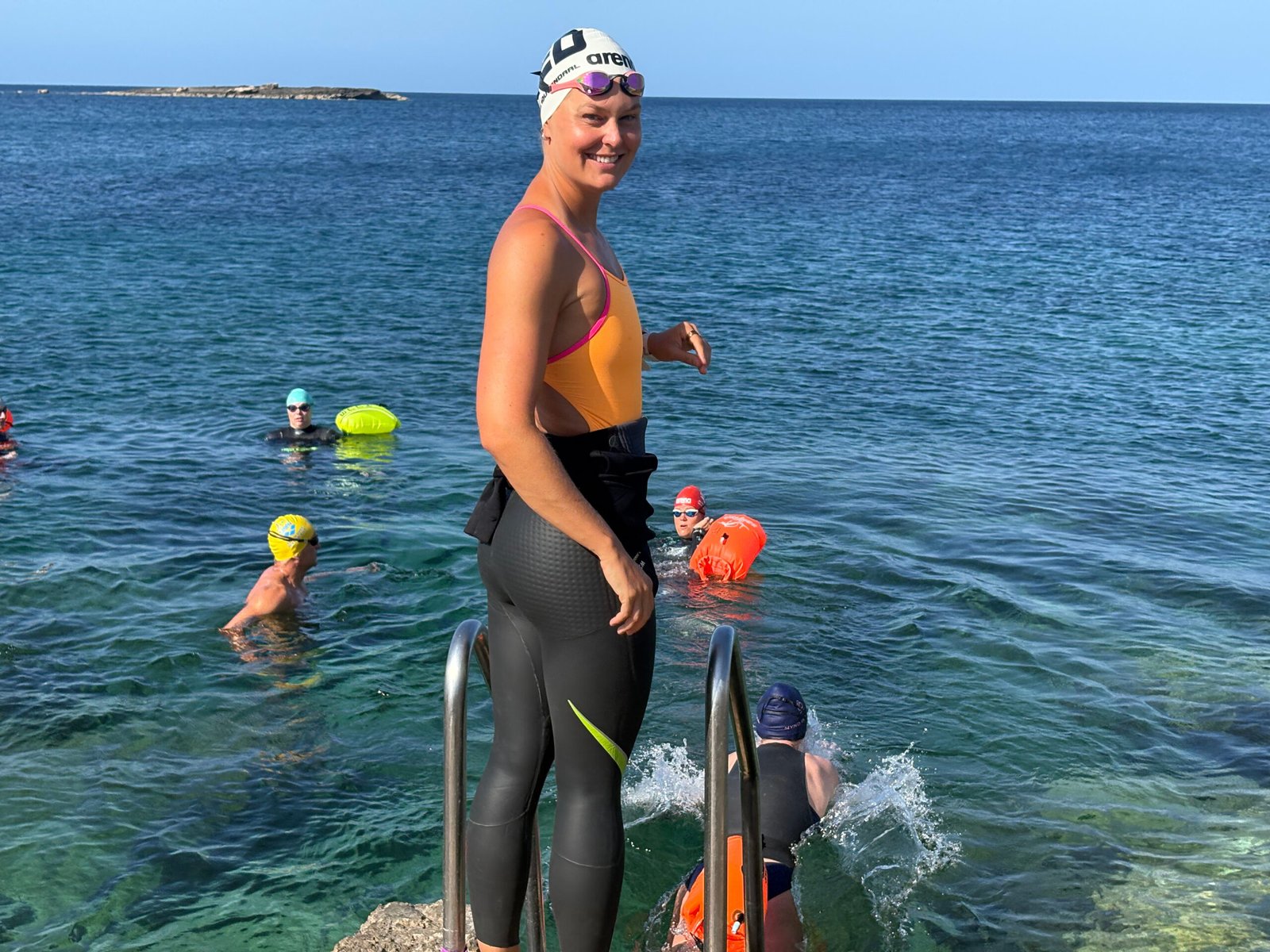 Sharon smiling beside the open water.