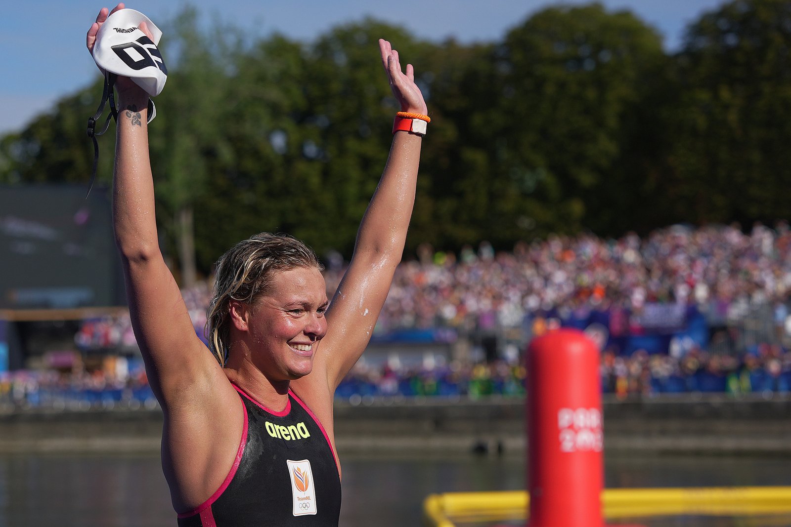 Sharon celebrating in the water with both arms raised.