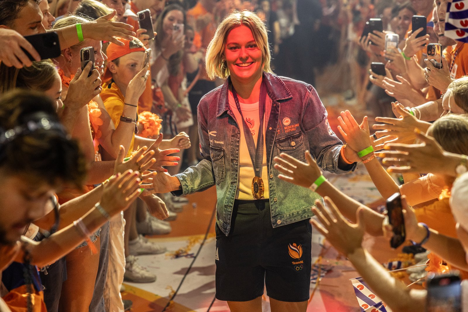 Sharon greeting supporters while wearing an Olympic medal.